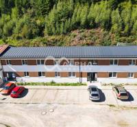 EXKLUZÍVNE 3i byt 113,09m2 s terasou, parkovaním, Nov. Huta - Budova na ulici Novoveská Huta v Spišskej Novej Vsi, obklopená autami a stromami.