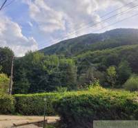 Stavebný pozemok pod lesom končiaci potôčikom v krásnom prírodnom pros - Pohľad na zelené kopce a zeleň v Beluši, vhodné pre Pozemky - bývanie.