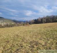 Stavebný pozemok s krásnym výhľadom nad obcou Jasenica pri Považskej B - Pohľad na záhrady s výhľadom na Jasenicu a okolité vrchy, pod zamračenou oblohou.