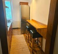 Prenájom pekný 3 izbový byt, Haburská ulica, Bratislava II. Ružinov - Úzka kuchyňa v 3-izbovom byte s plynovým sporákom, chladičkou a podlahou s dreveným dekorom.