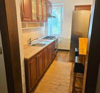 Prenájom pekný 3 izbový byt, Haburská ulica, Bratislava II. Ružinov - Kuchyňa v 3-izbovom byte s dreveným dekorom a svetlým kobercom.