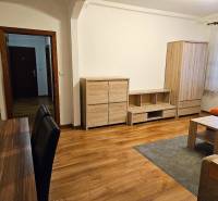 Prenájom pekný 3 izbový byt, Haburská ulica, Bratislava II. Ružinov - Obývacia izba v 3-izbovom byte s podlahou s dreveným dekorom a dreveným nábytkom.