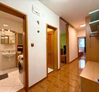 Na predaj – svetlý 2-izbový byt s loggiou a garážou | Bratislava - Chodba 2-izbového bytu s dlažbou, nábytkom a kúpeľňou.