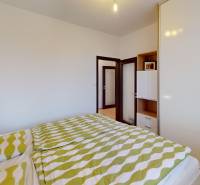 RADO I 4-izbový byt 97 m2 + loggia I Ivanka pri Dunaji  - Spálňa v 4-izbovom byte s posteľou, zelenou posteľnou bielizňou a vstavanou skriňou.