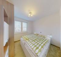 RADO I 4-izbový byt 97 m2 + loggia I Ivanka pri Dunaji  - Spálňa v 4-izbovom byte s posteľou, vstavanou skriňou a podlahou s dreveným dekorom.