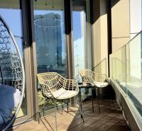 Prenájom 3-izbový byt s loggiou, SKY PARK, Bratislava - Balkón v 3-izbovom byte s ratanovými stoličkami a skleneným zábradlím.