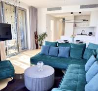 Prenájom 3-izbový byt s loggiou, SKY PARK, Bratislava - Obývacia izba v 3-izbovom byte so zelenou sedačkou a kuchynským kútom.