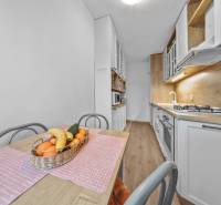 Ponúkame na predaj 3-izb.byt Vígľašská ul., Bratislava - Petržalka. - Kuchyňa v 3-izbovom byte s plynovým sporákom a podlahou s dreveným dekorom.