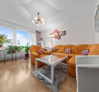 Ponúkame na predaj 3-izb.byt Vígľašská ul., Bratislava - Petržalka. - Obývačka s oranžovou sedačkou, podlaha s dreveným dekorom, v 3-izbovom byte.