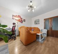 Ponúkame na predaj 3-izb.byt Vígľašská ul., Bratislava - Petržalka. - Obývacia izba so sedacou súpravou, pracovným stolom a podlahou s dreveným dekorom v 3-izbovom byte.