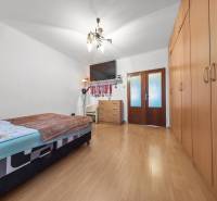 Ponúkame na predaj 3-izb.byt Vígľašská ul., Bratislava - Petržalka. - Spálňa v 3-izbovom byte s posteľou, skriňou a podlahou s dreveným dekorom.