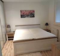 2-izbový byt, 49 m2, Cabanova ul., Bratislava - Dúbravka - Spálňa so šedou posteľou v 2-izbovom byte na ulici Cabanova, drevená podlaha.