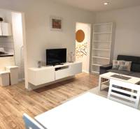 2-izbový byt, 49 m2, Cabanova ul., Bratislava - Dúbravka - Obývacia izba 2-izbového bytu na ulici Cabanova s kuchyňou a nábytkom.