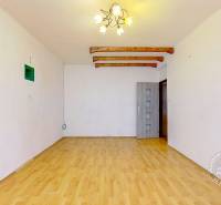 3-izbový byt S GARÁŽOU, Podolínec, ulica Družstevná - Obývacia izba v 3-izbovom byte s podlahou s dreveným dekorom a svetlým lustrom.