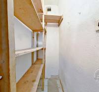 3-izbový byt S GARÁŽOU, Podolínec, ulica Družstevná - Úzka komora s drevenými policami v 3-izbovom byte, biele steny.