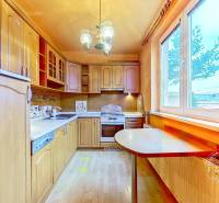 3-izbový byt S GARÁŽOU, Podolínec, ulica Družstevná - Kuchyňa s drevenými skrinkami a podlahou s dreveným dekorom v 3-izbovom byte.