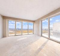 3i. BYT S VLASTNÝM TEP. ČERPADLOM + KLIMATIZÁCIA A EXTERIÉROVÉ ŽALÚZIE - Priestranná izba v 3-izbovom byte s veľkými oknami a výhľadom na krajinu.