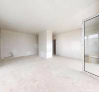 3i. BYT S VLASTNÝM TEP. ČERPADLOM + KLIMATIZÁCIA A EXTERIÉROVÉ ŽALÚZIE - Miestnosť v 3-izbovom byte s neomietnutými stenami a veľkými oknami.