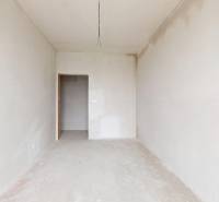 3i. BYT S VLASTNÝM TEP. ČERPADLOM + KLIMATIZÁCIA A EXTERIÉROVÉ ŽALÚZIE - Prázdna miestnosť v 3-izbovom byte s bielymi stenami a betónovou podlahou.