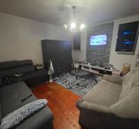 Útulný rodinný dom v tichej obci Hont, Maďarsko - Obývačka s dvoma pohovkami, televízor na stene, podlaha s dreveným dekorom.