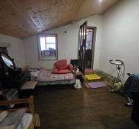 Útulný rodinný dom v tichej obci Hont, Maďarsko - Jedna izba v rodinnom dome s cvičebným bicyklom a podlahou s dreveným dekorom.