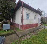 Útulný rodinný dom v tichej obci Hont, Maďarsko - Rodinný dom v Hont má bielu fasádu, okná s mrežami a vstupné schody.