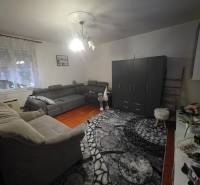 Útulný rodinný dom v tichej obci Hont, Maďarsko - Obývacia izba v rodinnom dome s sivou sedacou súpravou a podlahou s dreveným dekorom.