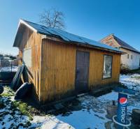 Na predaj 3 i RD v Partizánskom – Veľké Bielice, pozemok 1149 m2 - Za domom v Partizánskom, Veľkých Bieliciach, stojí drevená chatka na zasneženom dvore.