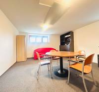 PRENÁJOM- KANCELÁRSKÝ PRIESTOR -120m2- KOMÁROVSKÁ - Kancelária v rodinnom dome s oknami, stolom, stoličkami, sedačkou a skriňou.