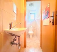 PRENÁJOM- KANCELÁRSKÝ PRIESTOR -120m2- KOMÁROVSKÁ - Kúpeľňa v rodinnom dome s umývadlom, toaletou a svetlým obkladom na stenách.