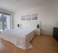 Prenájom 2 izbový 78 m2 + 30 m2 terasa,novostavba Koliba,zariadený - Svetlá spálňa v 2-izbovom byte s podlahou s dreveným dekorom a posuvnými dverami.