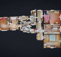 Rodinný dom Zvolen - Lieskovec - Pôdorys rodinného domu s viacerými izbami, kuchyňou a kúpeľňami, podlaha s dreveným dekorom.