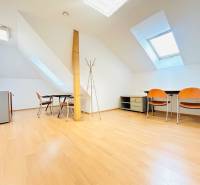 KANCELÁRSKE PRIESTORY- 120m2- KOMÁROVSKÁ - Kancelárie s podlahou s dreveným dekorom, podkrovné okná, stoly a stoličky.