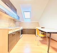 KANCELÁRSKE PRIESTORY- 120m2- KOMÁROVSKÁ - Kancelárie s kuchyňou a jedálenským stolom, svetlá podlaha s dreveným dekorom.