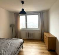 Prenájom pekný 3 izbový byt Jankolova ulica, Bratislava V. Petržalka - Spálňa s podlahou s dreveným dekorom, komodou a posteľou v 3-izbovom byte.