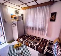 ‼️BRODZANY - ZÁHRADA S MUROVANOU CHATKOU NA PREDAJ, okr. PARTIZÁNSKE‼️ - Interiér chaty s chladničkou, gaučom, stolom a výhľadom do záhrady.