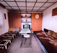 ‼️BRODZANY - ZÁHRADA S MUROVANOU CHATKOU NA PREDAJ, okr. PARTIZÁNSKE‼️ - Interiér chaty s posteľami, stolíkom, skrinkami a dekoráciami.