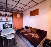 ‼️BRODZANY - ZÁHRADA S MUROVANOU CHATKOU NA PREDAJ, okr. PARTIZÁNSKE‼️ - Interiér chaty s pohovkou, jedálenským stolom a vstavanou skriňou, dominuje prírodná paleta farieb.