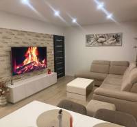  Prenájom 3-izbový byt, Nové Zámky - Obývačka v 3-izbovom byte s rohovou sedačkou a podlahou s dreveným dekorom.