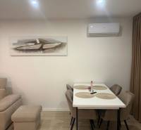  Prenájom 3-izbový byt, Nové Zámky - Jedáleň v 3-izbovom byte s podlahou s dreveným dekorom, stôl a stoličky.