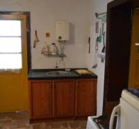 CHalúpka, na rekonštrukciu za cenu pozemku, dom Abrahám! - Kuchyňa v rodinnom dome s drevenými skrinkami a podlahou s dreveným dekorom.