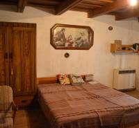 CHalúpka, na rekonštrukciu za cenu pozemku, dom Abrahám! - Spálňa v rodinnom dome s drevenou skriňou, posteľou a obrazom na stene.