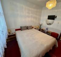 Na prenájom 3,5-izbový byt – Topoľčany, Sídlisko Východ - Spálňa v 3-izbovom byte s posteľou, lustrom a televízorom na stene.