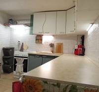 Útulný domček s dušou a moderným komfortom – Divín - Kuchyňa v rodinnom dome s bielymi tehlovými stenami a kuchynskými spotrebičmi.