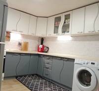 Útulný domček s dušou a moderným komfortom – Divín - Kuchyňa v Rodinnom dome s bielymi a šedými skrinkami, podlaha s dreveným dekorom.