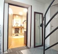 Útulný domček s dušou a moderným komfortom – Divín - Interiér rodinného domu so schodiskom, podlahou s dreveným dekorom a krbom.