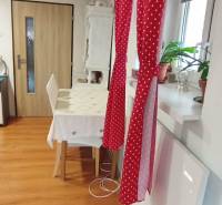 Útulný domček s dušou a moderným komfortom – Divín - Jedáleň v rodinnom dome s červeným závesom, stolom a podlahou s dreveným dekorom.