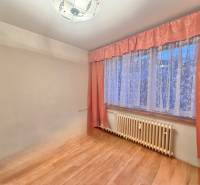 Predaj pôvodného 3+1 bytu v žiadanej lokalite v Čadci (MO) - Izba v 3-izbovom byte s podlahou s dreveným dekorom a závesmi.