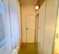 Predaj pôvodného 3+1 bytu v žiadanej lokalite v Čadci (MO) - Úzka chodba v 3-izbovom byte s podlahou a bielymi dverami.