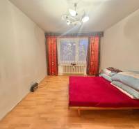 Predaj pôvodného 3+1 bytu v žiadanej lokalite v Čadci (MO) - Spálňa v 3-izbovom byte s posteľou, podlahou s dreveným dekorom a svetlom.